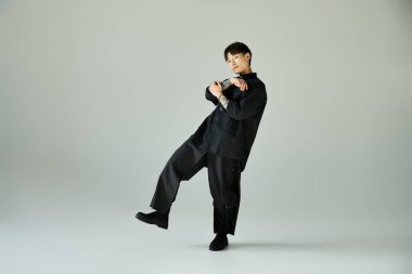 Yakışıklı Asyalı bir adam şık bir şekilde minimalist bir arkaplana karşı poz verir..