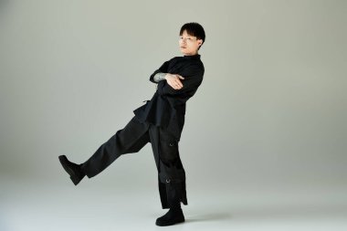 Yakışıklı bir Asyalı zarif duruyor, özgüven ve yetenekle çağdaş moda sergiliyor..