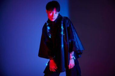 Modaya uygun genç adam modern stili aydınlatıcı detaylar ve gece koyu renkleriyle sergiliyor..