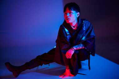 Yakışıklı adam kendine güvenen bir pozla kendine has tarzını sanatsal bir ortamda sergiliyor..