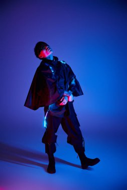 Şık bir genç adam dikkat çekici bir kıyafetin içinde duruyor ve eşsiz yeteneğini sergiliyor..