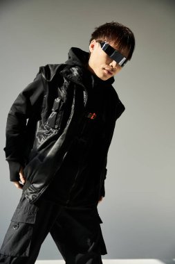 Şık bir Asyalı, şık siyah bir elbiseyle modern yeteneklerini sergileyerek özgüvenle poz verir..