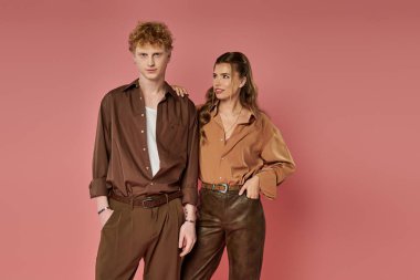 Şık çift canlı bir arkaplan karşısında sıcaklık ve bağlantı yayıyor.