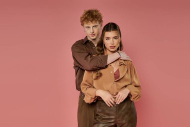 Neşeli bir çift, neşeli bir şekilde kaynaşıyor, modaya uygun kıyafetler giyip, pembe bir arka plana geçiyorlar..