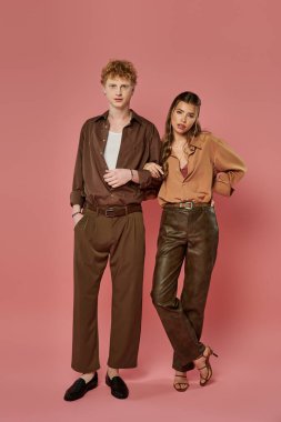 Moda kıyafetleri giymiş genç bir çift renkli bir ortamda keyifli bir anın tadını çıkarıyor..