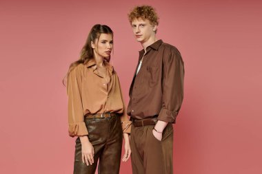 İki genç, hareketli bir arkaplan karşısında şık kıyafetler içinde birleşiyor..