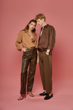 Şık bir çift cesur bir arka plana karşı sevgi dolu, kendine güvenen bir anı paylaşıyor..