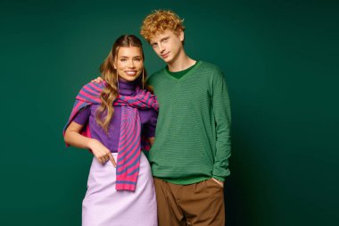 Genç bir çift şık kıyafetler içinde, sevgi ve bağlılık saçarak neşeyle kucaklaşır..