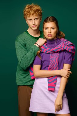 Şık genç çift, birbirlerine güven içinde poz verirken modaya uygun kıyafetlerini sergiliyor..