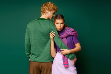 Şık bir çift, modern bir dokunuşla renkli giysiler içinde bir sevgi anı yakalar..