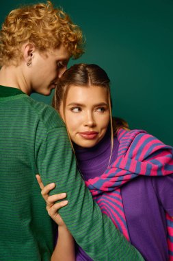 Şık bir çift, romantik bir bağ kurarken nazikçe, modern kıyafetlerini sergiliyor..