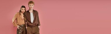 Tarz sahibi bir çift, pembe bir arka plana güvenerek modern romantizm ve cazibe yayıyor..