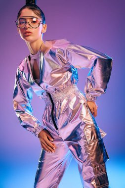 Şık bir kadın metalik giysiler içinde, parlak ışıklar altında holografik renklerle parlıyor..