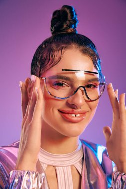 Tarz sahibi genç bir kadın, holografik renklerle vurgulanmış fütüristik kıyafetlere güvenir..