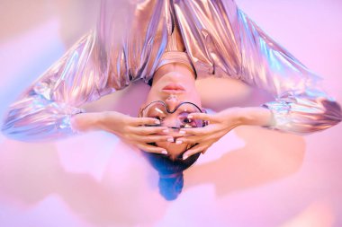 Genç bir kadın canlı holografik tarzını sergiliyor, kendine güveni ve yeteneği yayıyor..