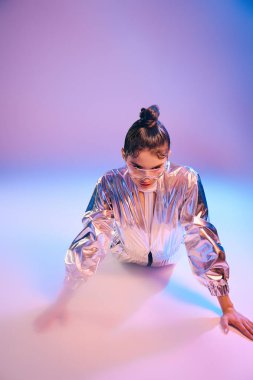 Metalik moda içinde genç ve güzel bir kadın renkli çevresiyle şakalaşıyor..