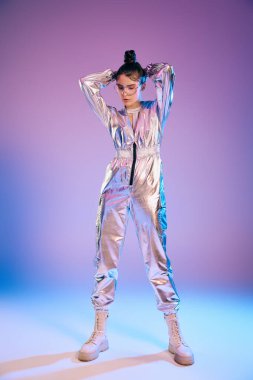 Genç bir kadın, holografik renkleri ve modern bir atmosferi olan fütüristik kıyafetlerle güvenle ayakta duruyor..