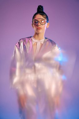 Genç bir kadın, çarpıcı fütüristik kıyafetini holografik tonlarıyla ve modern yetenekleriyle modelliyor..