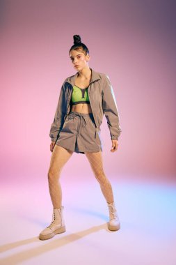 Genç bir kadın, renkli bir geçmişle aydınlatılmış çarpıcı bir kıyafetle modern moda sergiliyor..