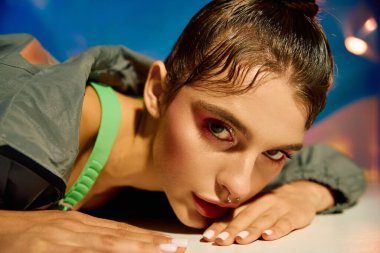 Yüzeye yakın şık bir kadın holografik bir arkaplan karşısında modern titreşimler yayıyor..