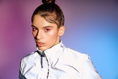 Kendine güvenen genç bir kadın, canlı bir holografik arkaplan karşısında şık giyiniyor..