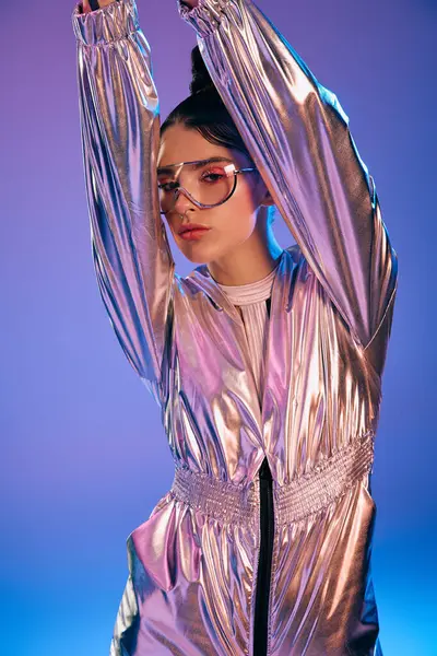 Genç bir kadın parlak holografik renklerle parıldayan fütüristik giysiler içinde parlıyor..