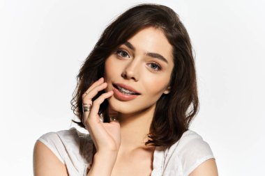 Çekici, genç bir kadın ışıl ışıl gülümseyen şık yaz kıyafetleri giyiyor..