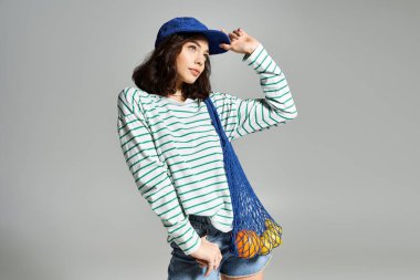 Neşeli bir ifadesi ve taze meyveleri olan genç bir kadın için parlak ve modaya uygun bir yaz kıyafeti..