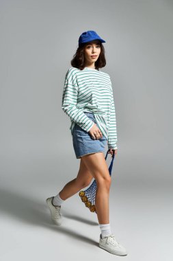 Kendine güvenen genç bir kadın şık bir yaz elbisesi içinde dolaşır, canlı stilini ve yeteneğini sergiler..