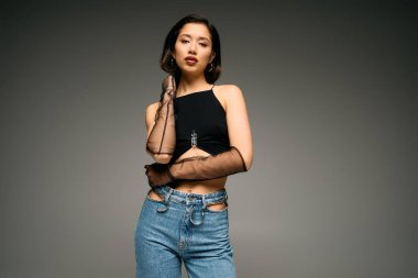 Çekici genç kadın modern moda anlayışını zarif bir pozla sergiliyor..