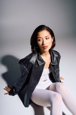 Genç bir kadın şık bir stüdyoda otururken eşsiz moda anlayışını sergiliyor..