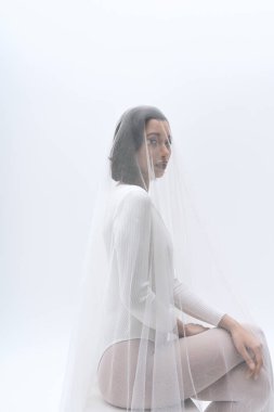 Genç bir gelin zarif bir peçe takarak zarafet sergiliyor. Güzellik ve sükunet anı yaratıyor..