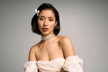 Şık bir elbise ve inci aksesuarlı genç bir gelin yumuşak ışıkta zarafet saçar..