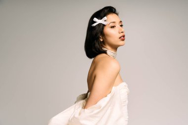 Güzel genç bir gelin büyüleyici gelinliğini sergilerken cazibesini ve zarafetini sergiler..