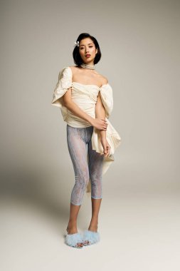 Güzel genç bir gelin zarif bir şekilde duruyor, eşsiz elbisesini ve büyüleyici çekiciliğini sergiliyor..