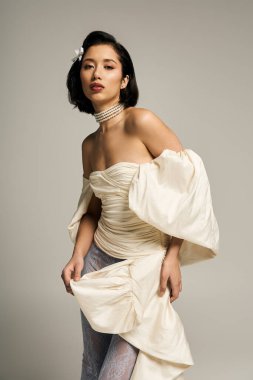 Güzel, genç bir gelin zarif elbisesini ve kendine güvenini sergiliyor..