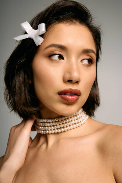 A young bride shines with beauty in a pearl choker and elegant accessories, radiating charm.