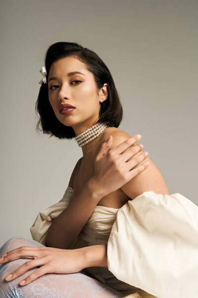 A young bride delights with her beauty in a delicate gown, radiating joy and anticipation.