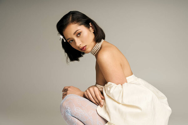 A young bride poses gracefully, radiating beauty in a serene, elegant atmosphere.