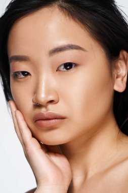 Sakin bir ifadeyle, doğal güzelliği ve zarafeti sergileyen genç bir Asyalı kadını yakından çek..