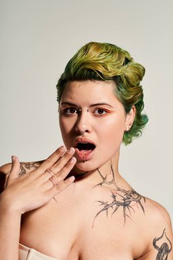 Çarpıcı dövmeleri ve kalın saç rengi olan genç ve güzel bir kadın şık bir ortamda heyecan gösteriyor..