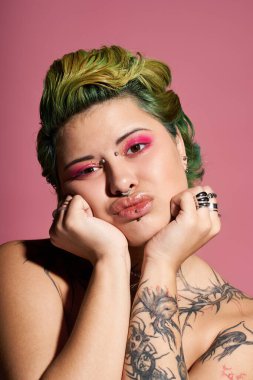 Genç bir kadın sanatsal makyaj ve şık bir görüntü sergiliyor, kameraya güvenli bir şekilde poz veriyor..