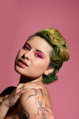 Şık bir genç kadın şık bir makyaj ve sanatsal bir saç stiliyle zarif poz verir..