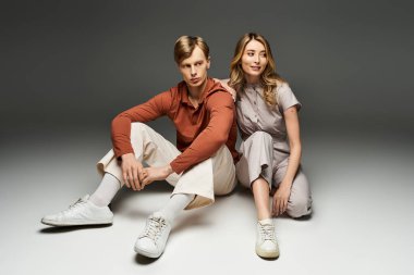 Genç bir çift bahar kıyafetlerini sergiliyor, gösterişli bir stüdyoda ışıl ışıl parlıyorlar..