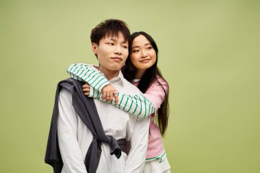 Erkek ve kadın, modalarını canlı bir ortamda sergilerken şefkatle kucaklaşırlar..