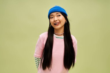 Pastel arka planda şık giyinmiş neşeli çekici kadın..