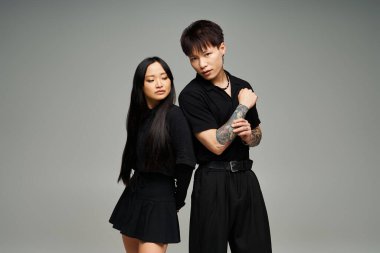 İki şık insan romantizmini tarafsız bir arkaplanda yaratıcı bir pozla ifade eder..