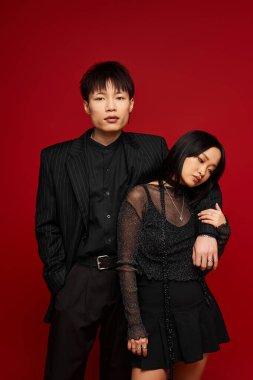 Bir çift, şık giysiler içinde zarif bir şekilde poz vererek, sevgilerini sergiliyor..