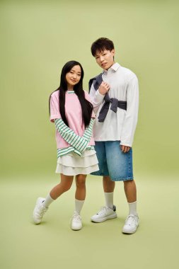 Şık bir çift, şık kıyafetler ve rahat bir ortamda neşeli gülümsemeler sergiliyor..