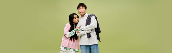 A couple showcases their trendy fashion as they share a sweet moment, exuding love and joy.